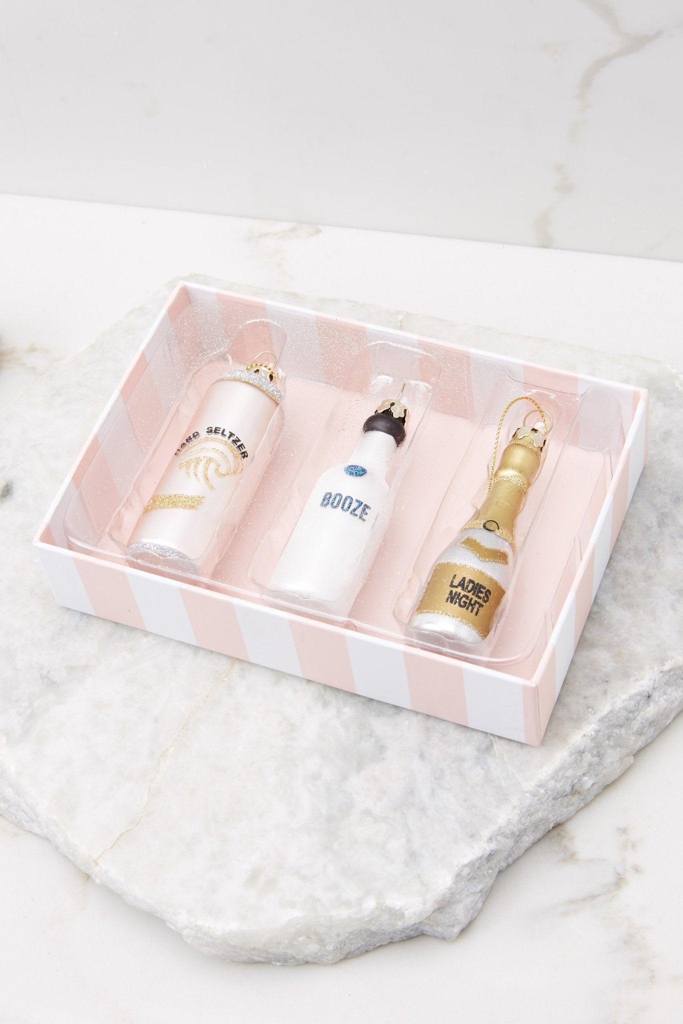 This set includes: one hard seltzer can, one champagne bottle that says "ladies night," and one white bottle that says "booze."