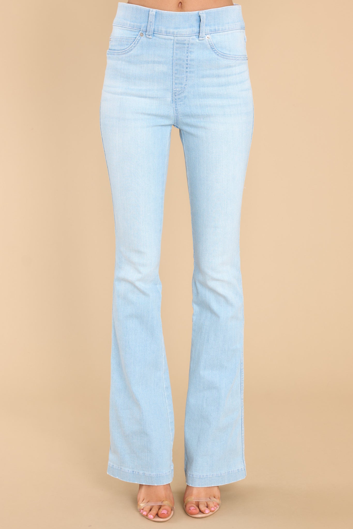 Front view of these jeans that feature flared legs, decorative front pockets, and belt loops.